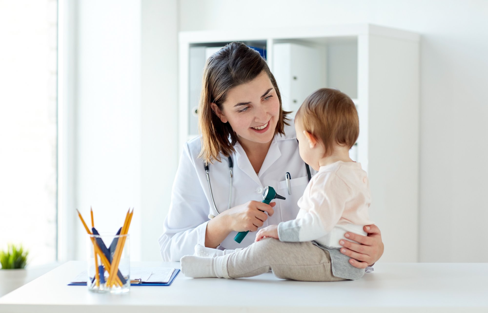 doctor-with-baby-and-otoscope-at-clinic-P9LY8JW